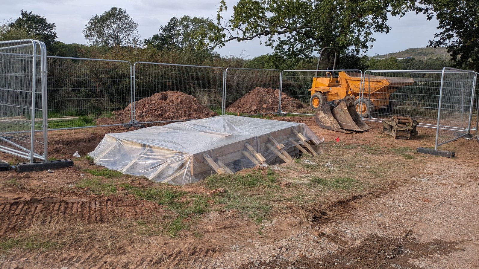 A freshly poured concrete base covered over to cure and stay protected from the weather.