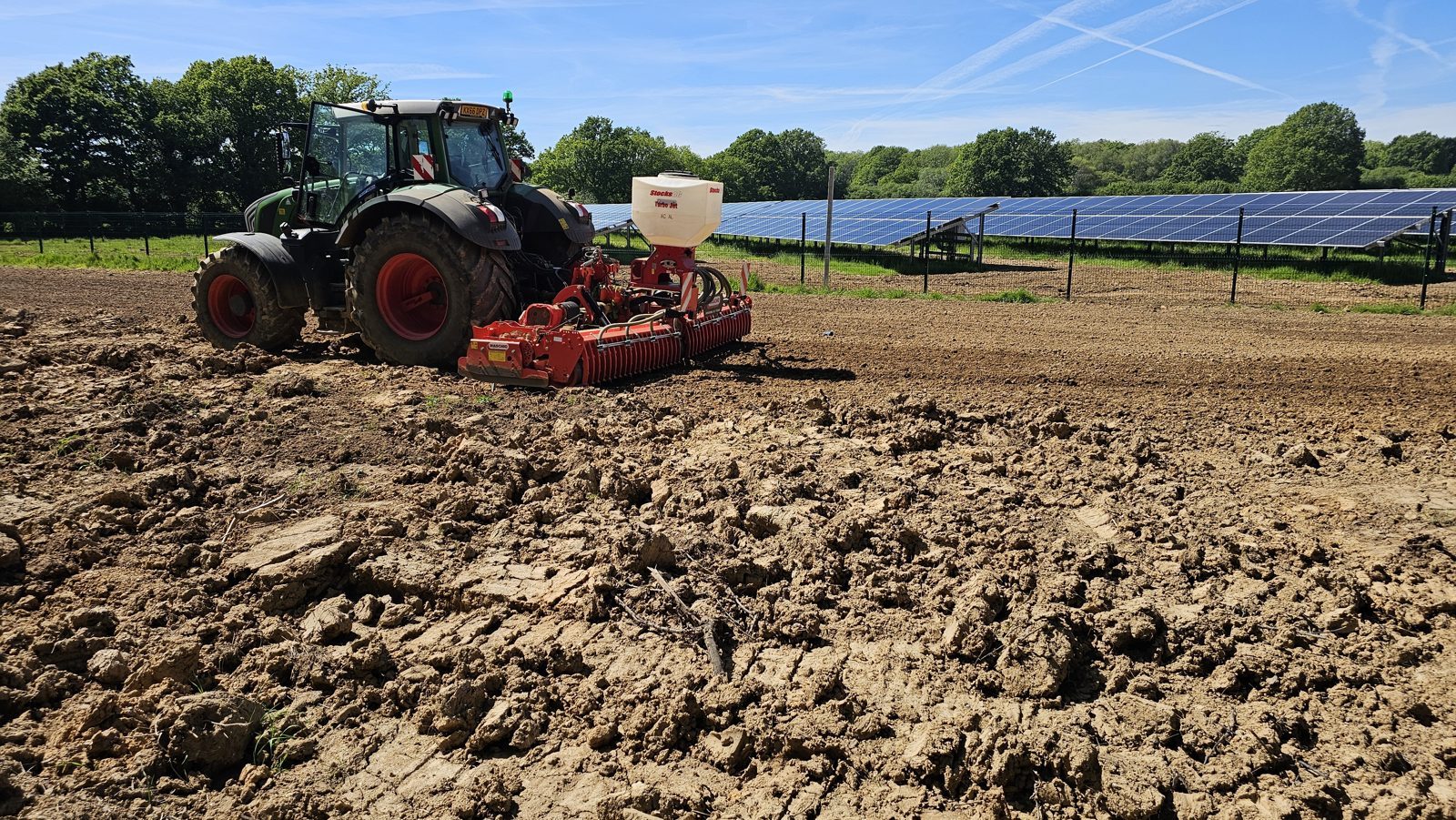 A tractor cultivating and seeding ground for reinstatement at a completed solar site in East Sussex.