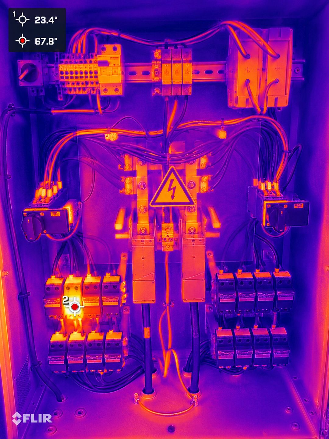 Thermal image of the same combiner box, with one string fuse glowing at 67.8&deg;C against a 23.4&deg;C reference point.