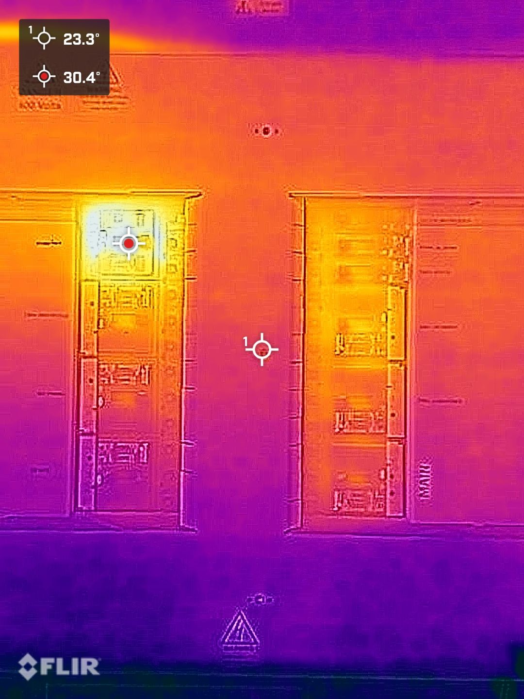 Thermal image of two electrical cabinets, with a warm spot at the top of one reading 30.4&deg;C against 23.3&deg;C on the door beside it.